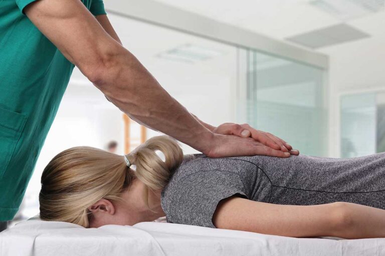 Person lifting a laundry basket with bent knees and the load held close to the body.